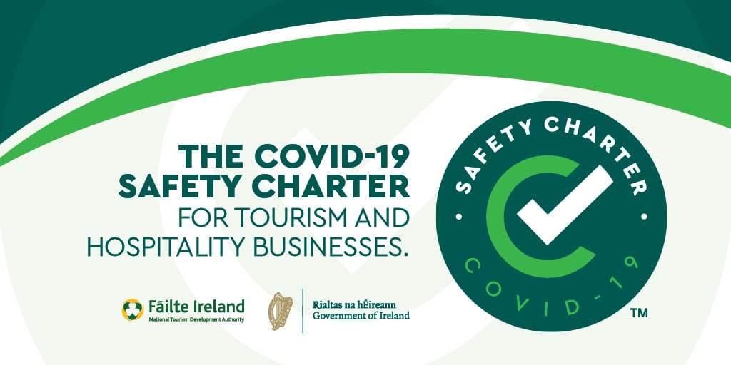 A graphic promoting the COVID-19 Safety Charter and COVID 19 Policy for tourism and hospitality businesses, featuring a large checkmark logo along with the logos of Fáilte Ireland and the Government of Ireland.